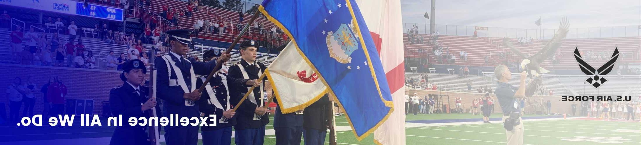 Excellence in all we do overlaying Air Force cadets at football game.