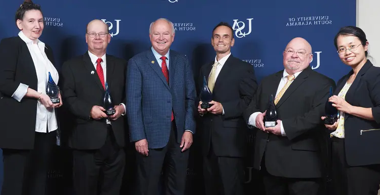 The University of South Alabama recognized five of its faculty members for excellence in research at the 2nd annual USA Technology and Research Showcase Oct. 24. From left, Dr. Na Gong, professor of electrical and computer engineering; Dr. James Davis, professor of chemistry; Dr. Jordan Shropshire, professor of information systems and technology; USA President Jo Bonner; Dr. Sean Powers, professor of marine and environmental sciences and senior marine scientists at the Dauphin Island Sea Lab; Dr. Marie Migaud, professor of pharmacology and oncology.