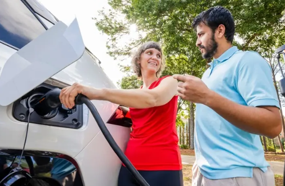 Dr. Daniela Touma next to electric car.